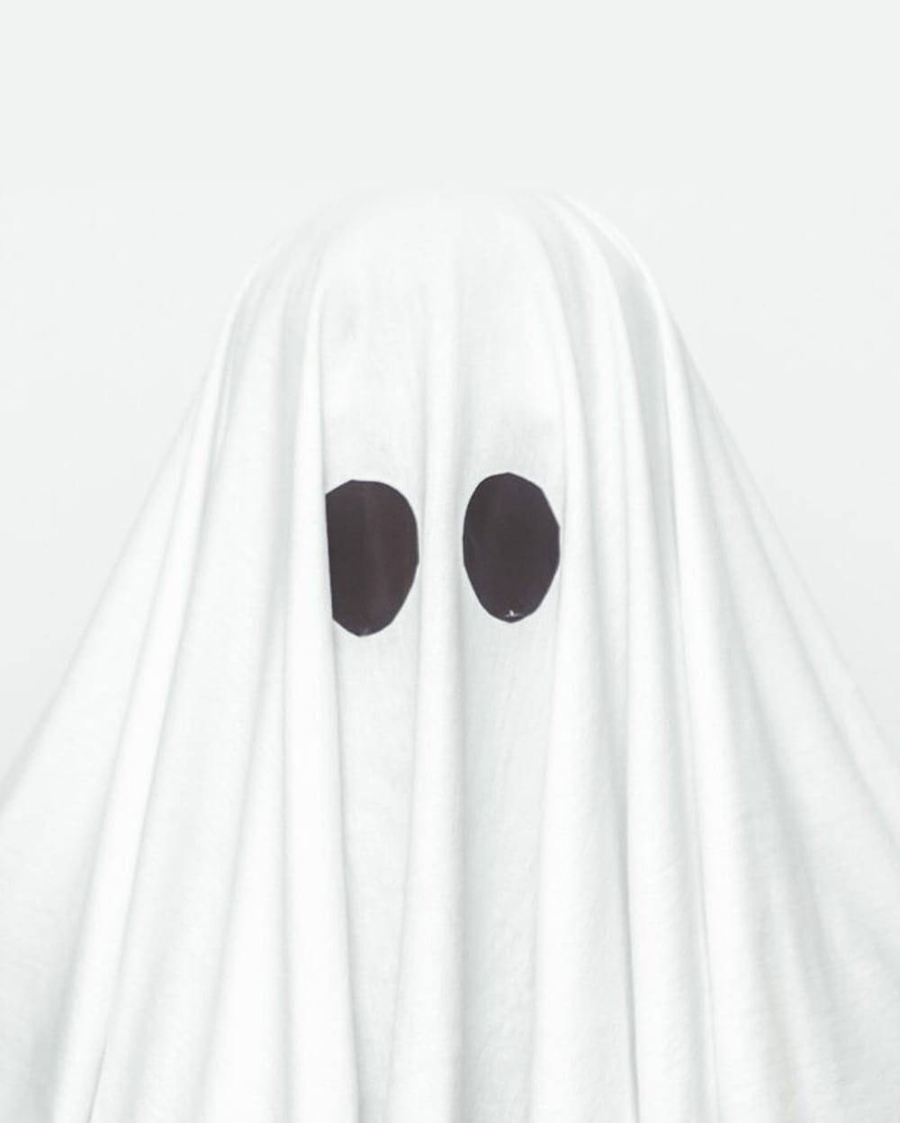 A person dressed as a ghost by using a bedsheet.