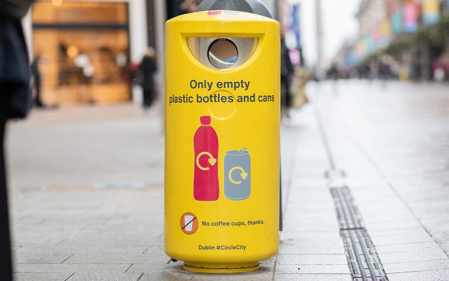 A yellow In The Loop recycling bin on a street in Dublin.