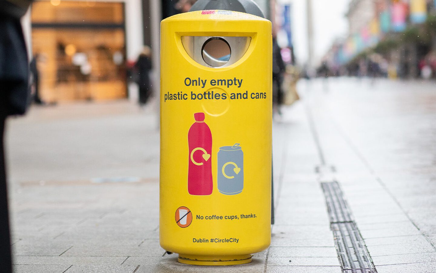 A yellow In The Loop recycling bin on a street in Dublin.