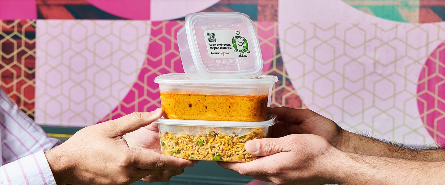 Two people passing three Tupperwares of food to each other.