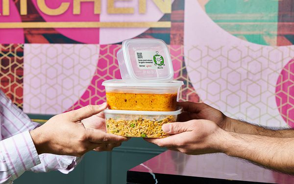 Two people passing three Tupperwares of food to each other.