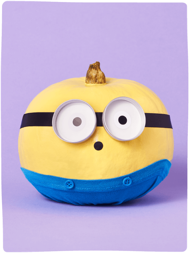 Pumpkin painted and decorated like a Minion from Despicable Me sat against a light purple backdrop.